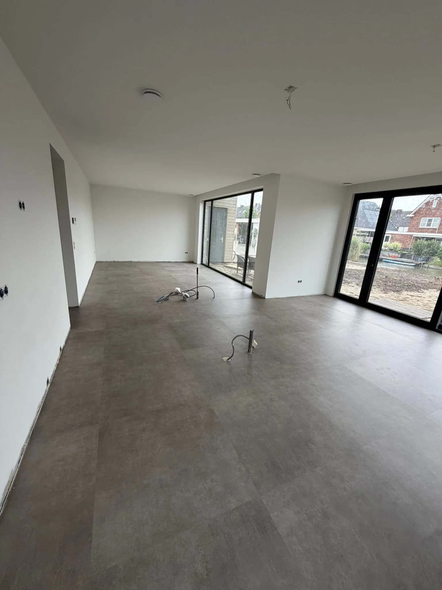 Betonlook PVC vloer in een nieuwbouwwoning met grote raampartij