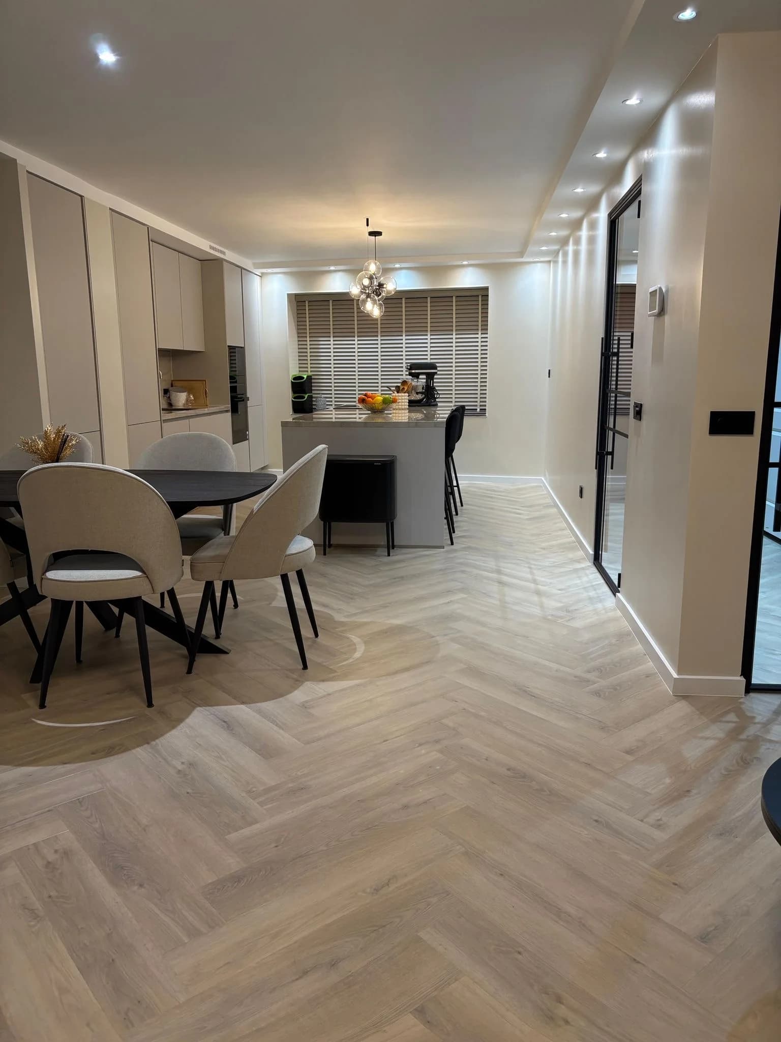 Visgraatvloer in een ingerichte eetkamer met open keuken