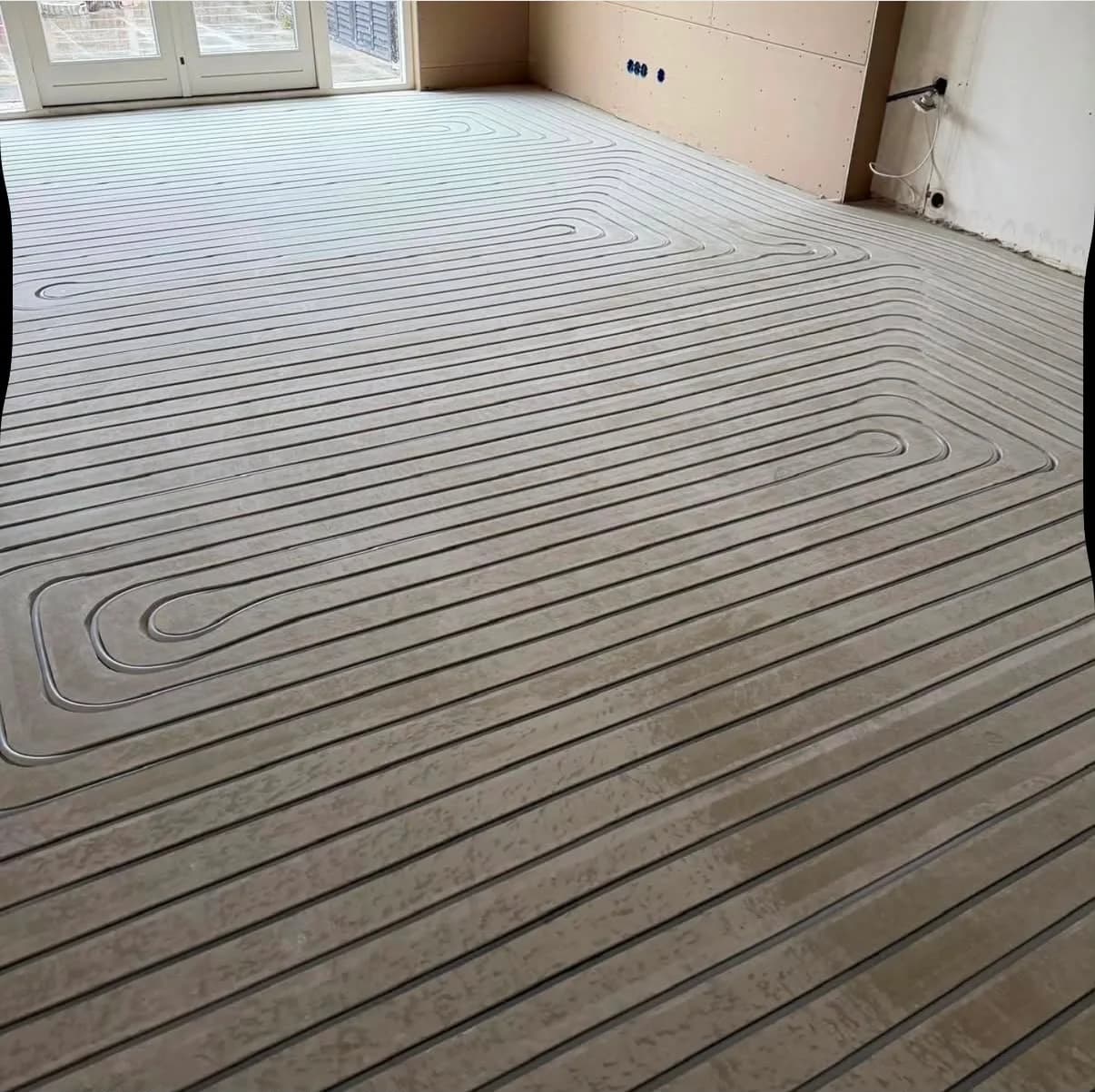 Vloerverwarming ingefreesd in de dekvloer, klaar om dichtgesmeerd te worden