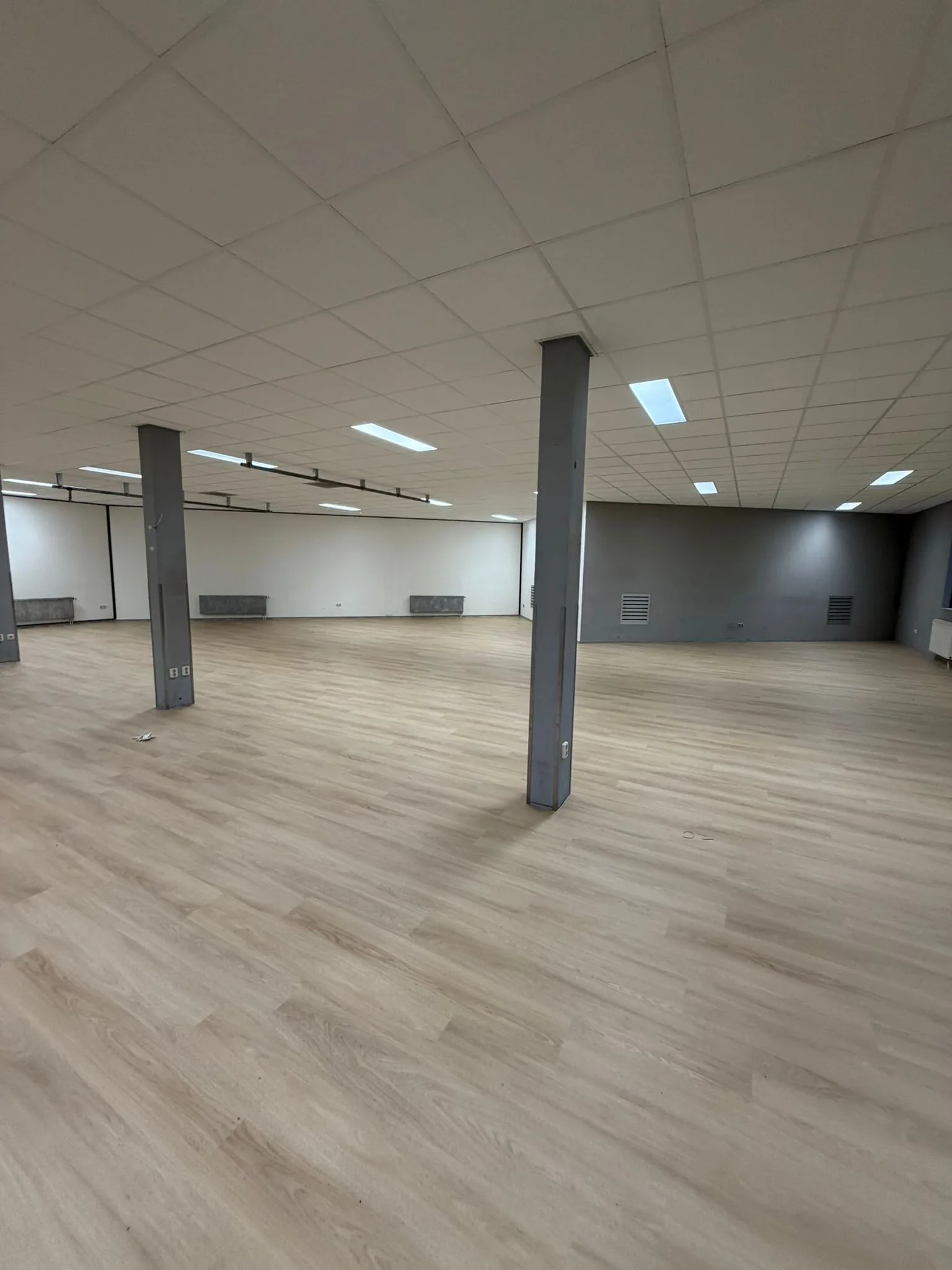 Lichte PVC vloer in een bedrijfsruimte met stalen kolommen