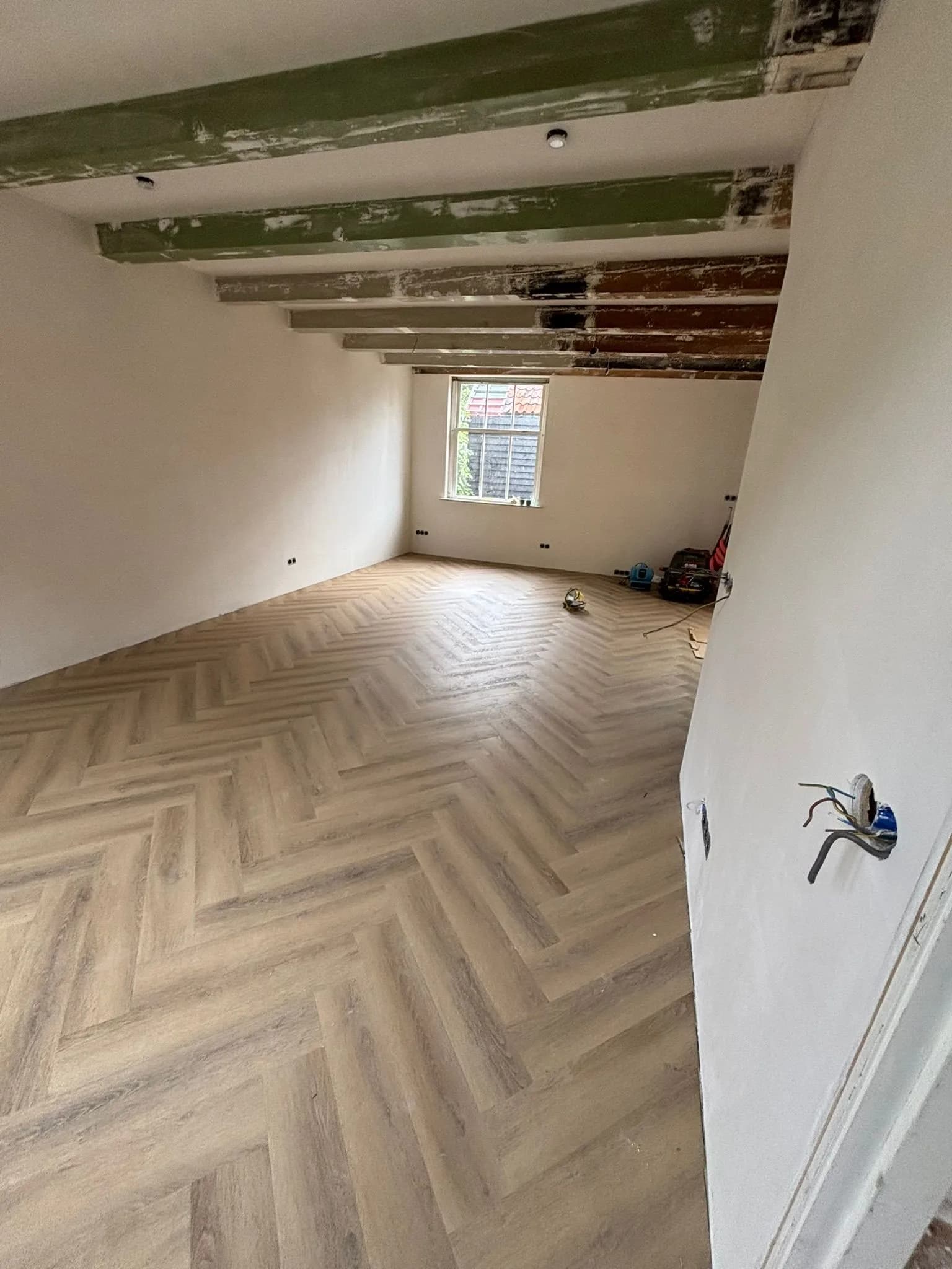 Visgraatvloer in een gerenoveerd pand met zichtbare balken