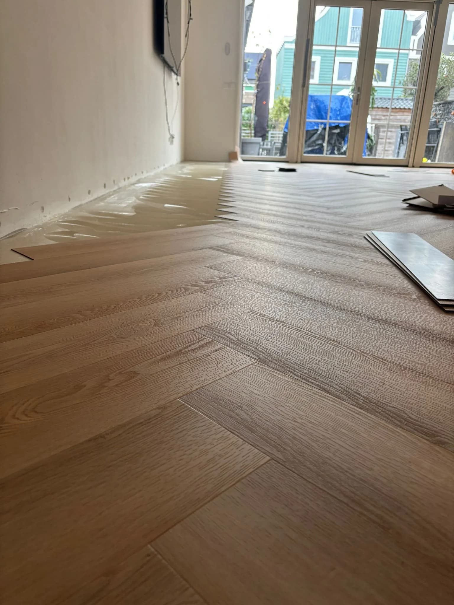 PVC vloer wordt gelegd: planken half geplaatst op de geëgaliseerde ondervloer