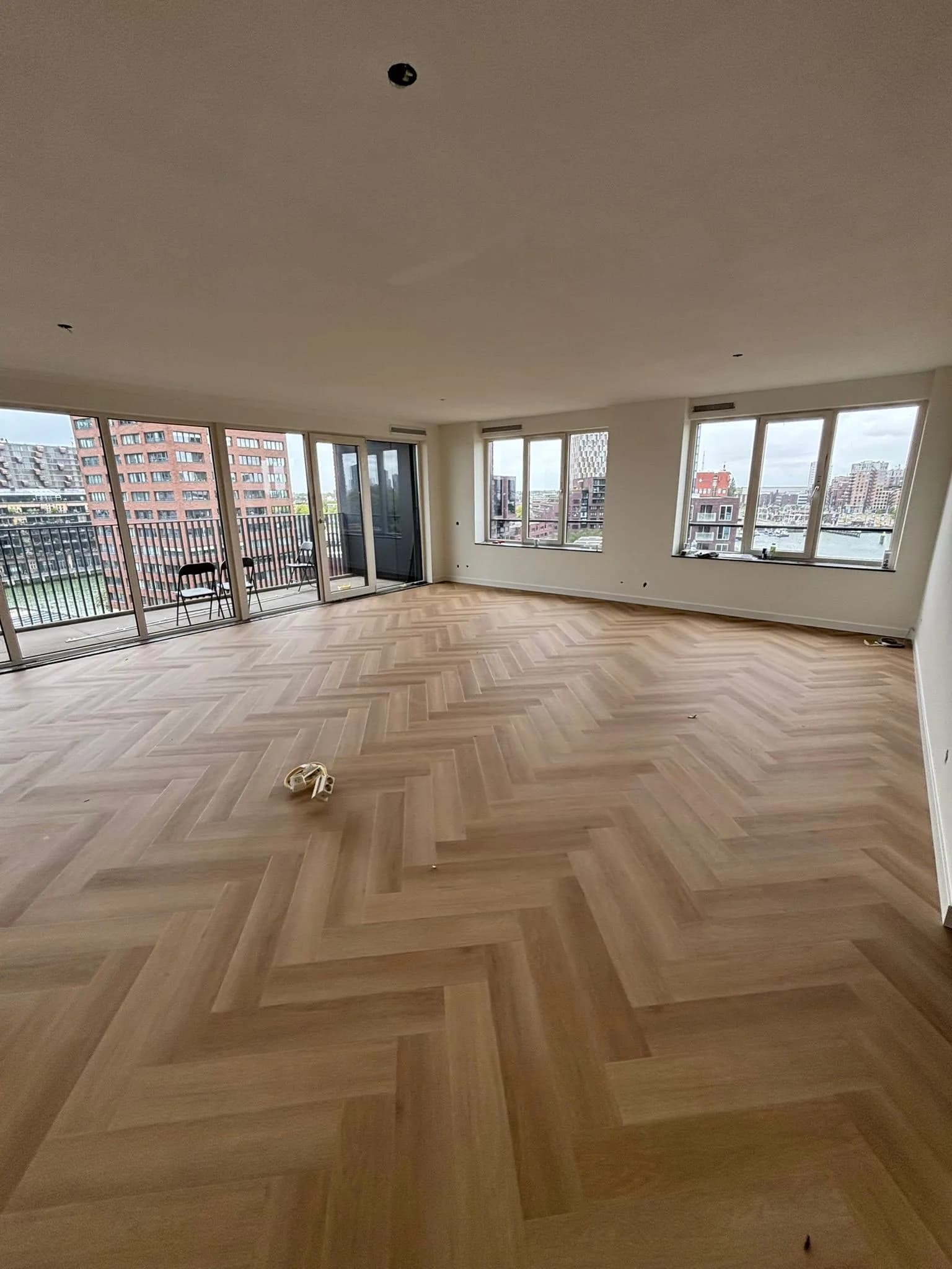 Visgraatvloer in een appartement met uitzicht over de haven