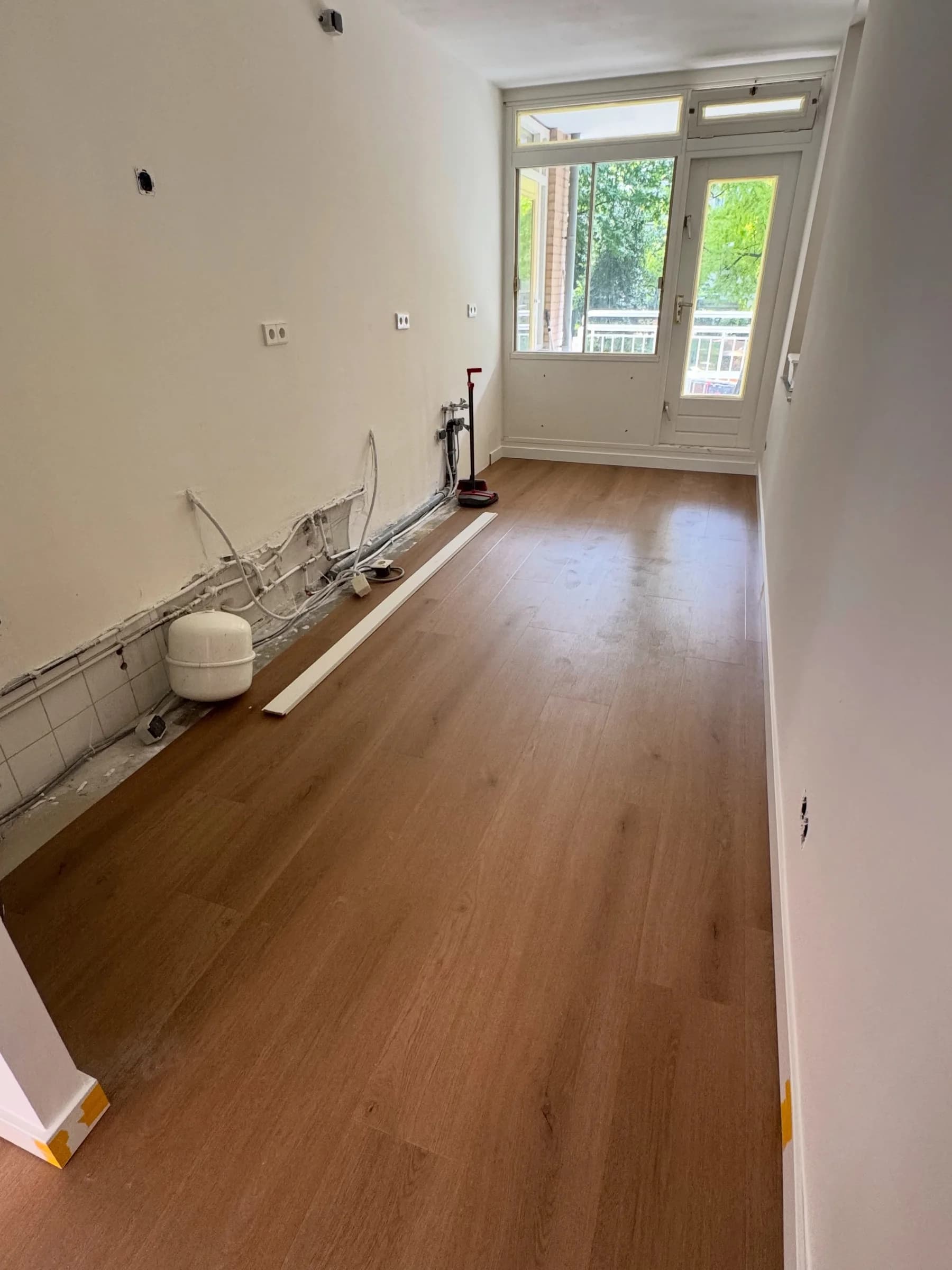 Rechte strook PVC vloer in een slaapkamer met leidingwerk in de hoek