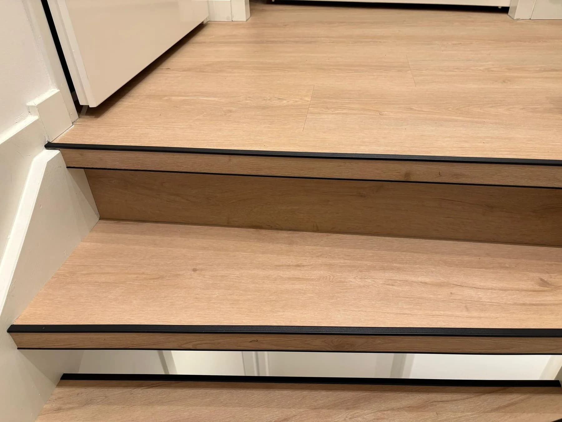 Detail van een PVC traptrede met zwarte anti-sliprand