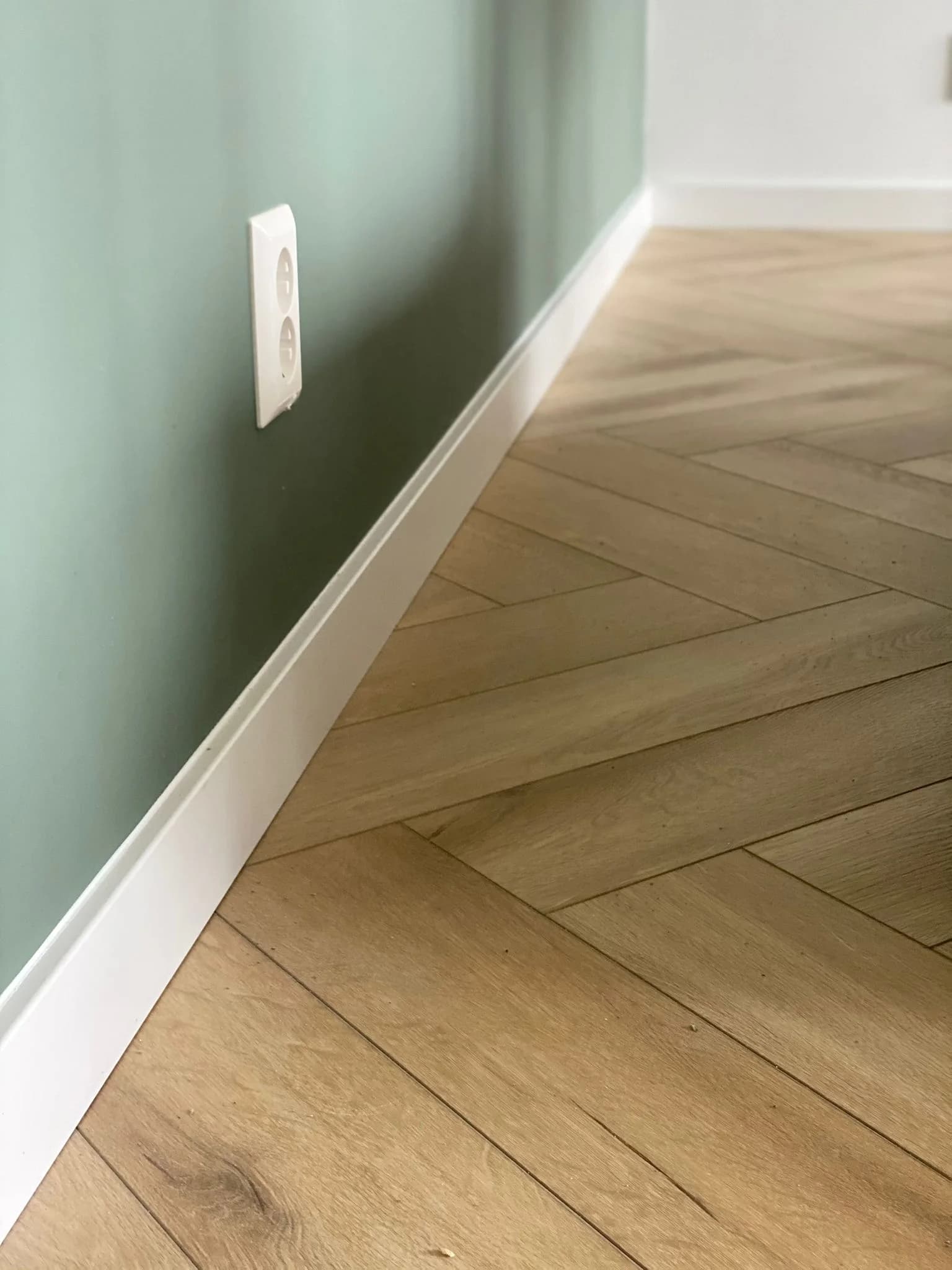Detail van walvisgraat: brede planken in visgraatverband langs een plint