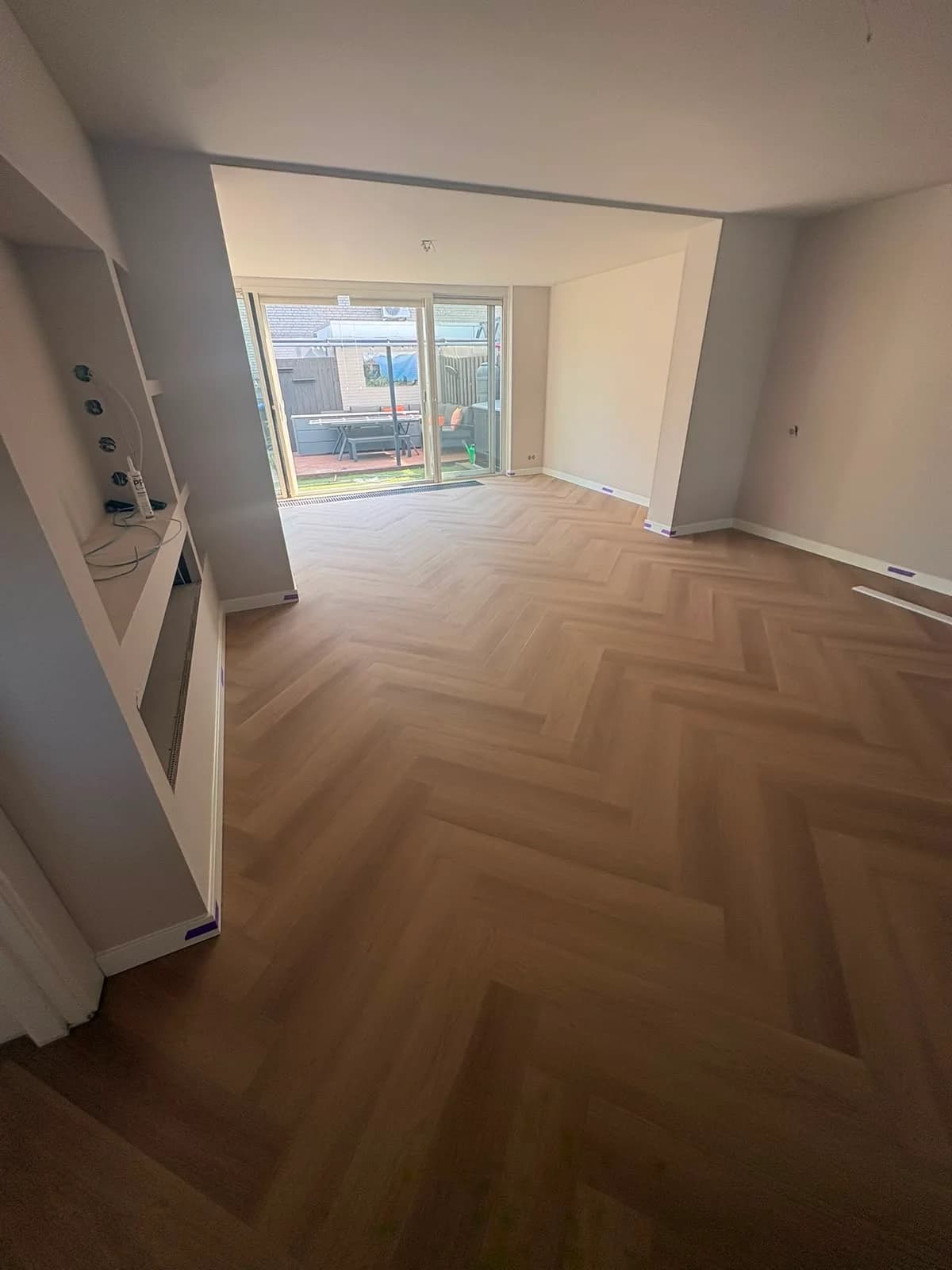Walvisgraatvloer in een woonkamer met openslaande tuindeuren