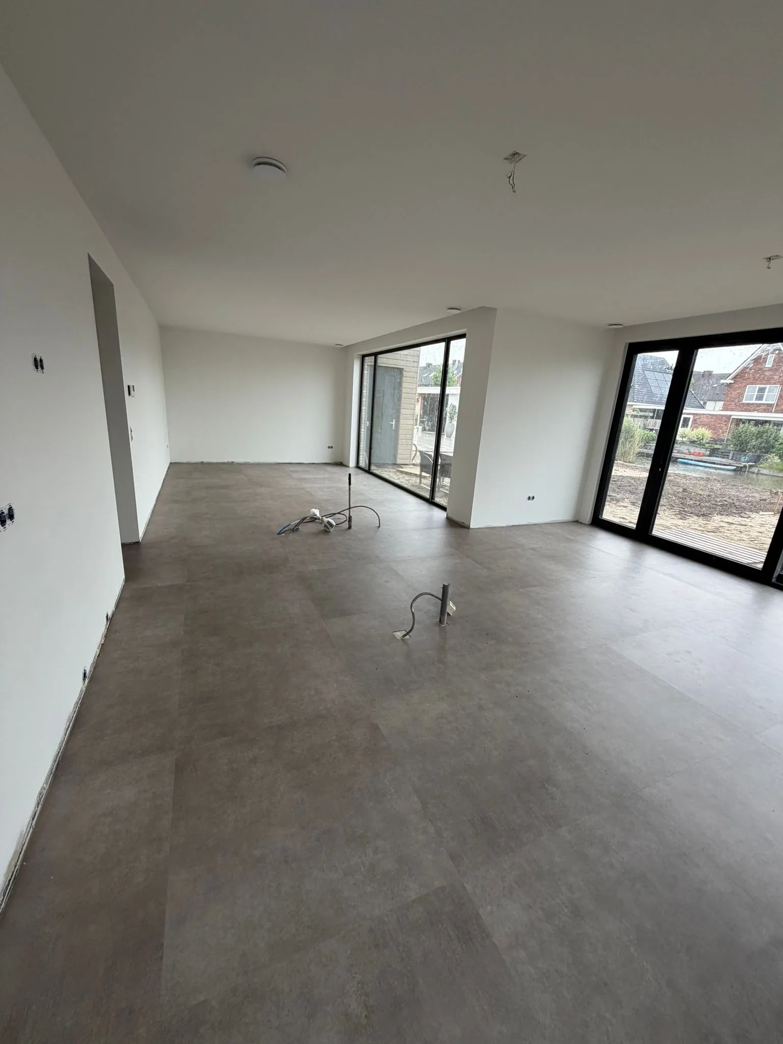 Betonlook PVC vloer in een nieuwbouwwoning met grote raampartij